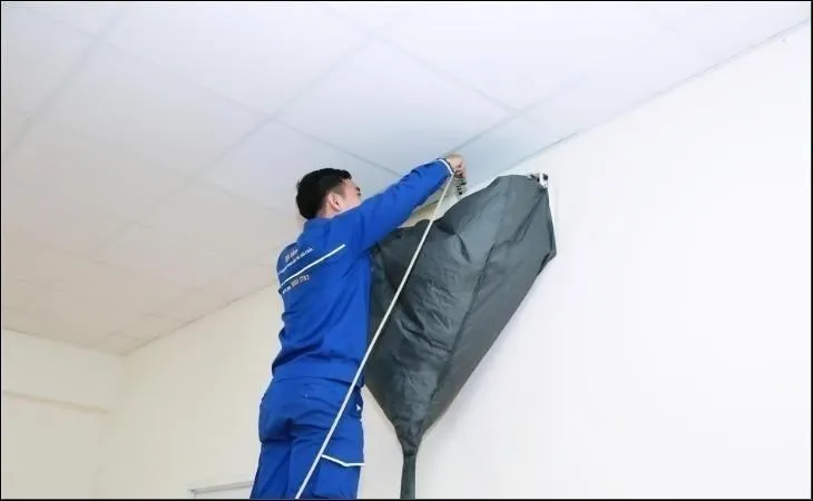 Nhân viên kỹ thuật đang tiến hành kiểm tra và vệ sinh hệ thống cảm biến trên máy lạnh