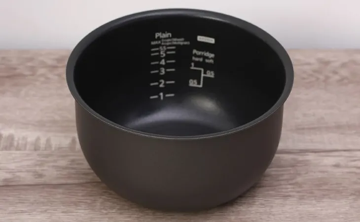 Đáy lòng nồi cơm điện tử Tiger 1 lít JAX-S10W bị cong vênh làm giảm tiếp xúc với mâm nhiệt