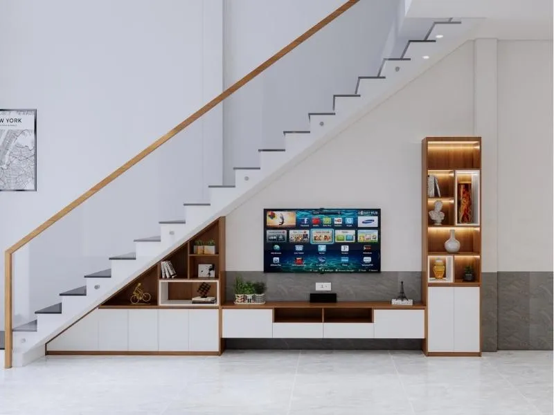 Bày trí kệ tivi gầm cầu thang cân đối với sofa, bàn trà và cây xanh để tạo sự hài hòa