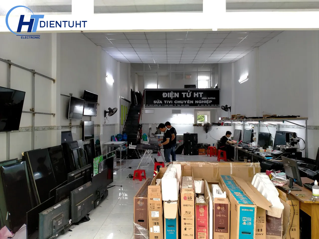 Cận cảnh một kỹ thuật viên đang kiểm tra mạch điện tử bên trong tivi