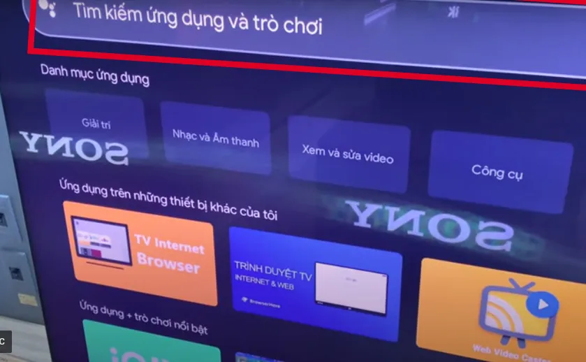 Nhấn vào nút Home trên điều khiển tivi -> Chọn vào ô tìm kiếm -> Gõ Mytv vào biểu tượng kính lúp để tiến hành tìm kiếm