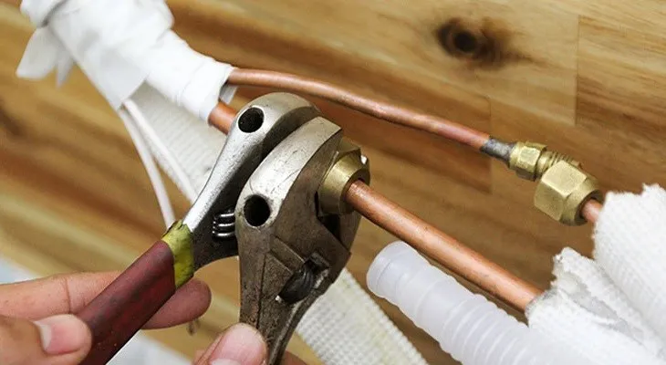 Kỹ thuật viên chuyên nghiệp sử dụng đồng hồ đo áp để kiểm tra gas trước khi tháo máy