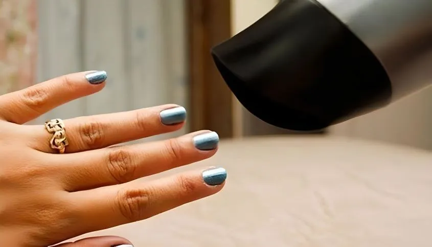 Ứng dụng luồng khí từ máy sấy tóc để làm khô sơn móng tay nhanh chóng.